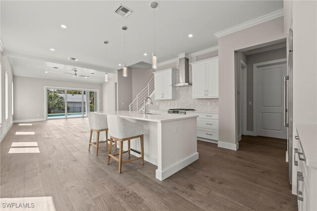 1134 Trail Terrace Dr, Naples, FL 34103 - kitchen featuring open floor plan, wall chimney exhaust hood, backsplash, visible vents, and wood finished floors