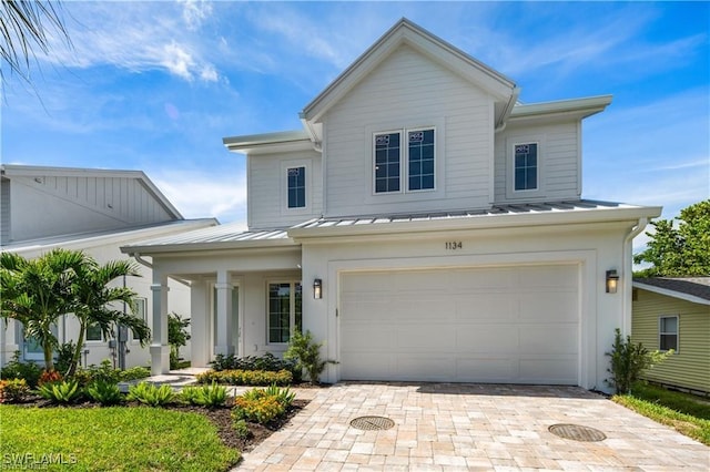 1134 Trail Terrace Dr, Naples, FL 34103 - view of front of home with metal roof, decorative driveway, an attached garage, and a standing seam roof
