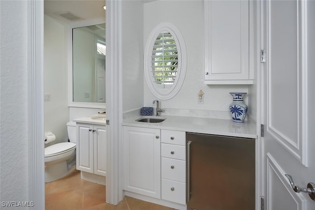 bathroom with toilet, visible vents, tile patterned floors, and vanity