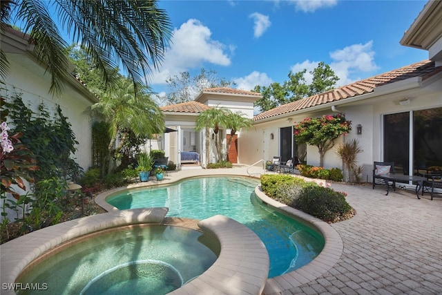 view of pool with a patio and a pool with connected hot tub