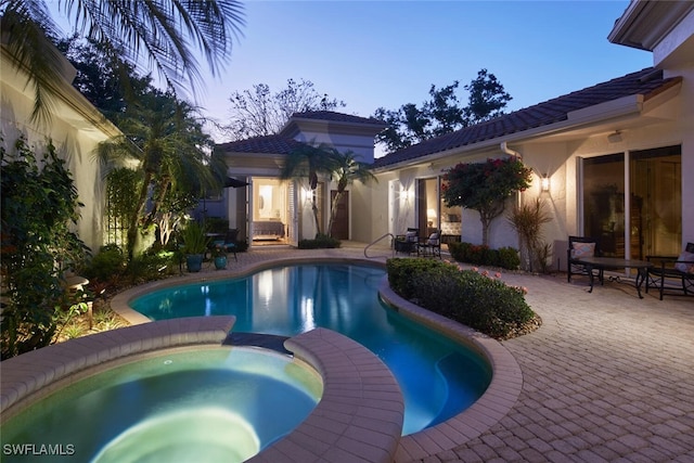 pool featuring a patio area and an in ground hot tub
