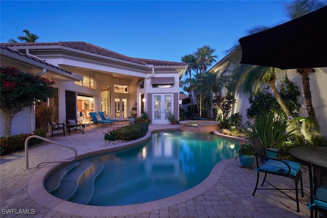 view of pool featuring french doors, a patio area, and a pool with connected hot tub