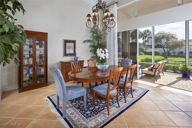 dining space featuring an inviting chandelier, light tile patterned flooring, and a towering ceiling