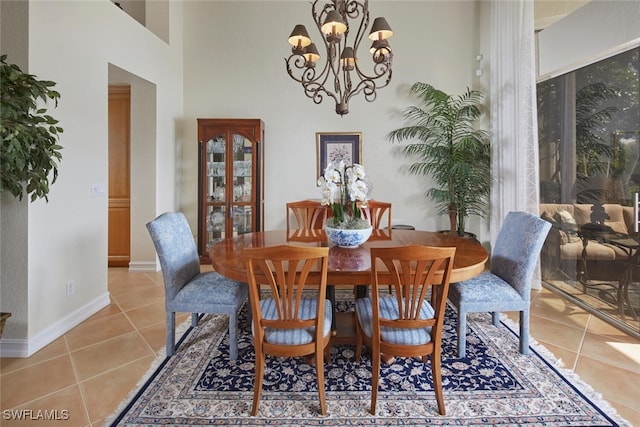dining room featuring light tile patterned floors, baseboards, and a notable chandelier