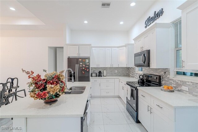 233 39th Ave NE, Naples, FL 34120 - kitchen featuring black appliances, a sink, light marble finish floors, a center island with sink, and white cabinets