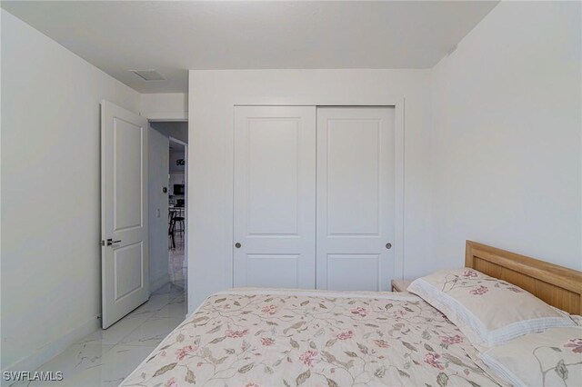 233 39th Ave NE, Naples, FL 34120 - bedroom with light marble finish floors, a closet, and baseboards