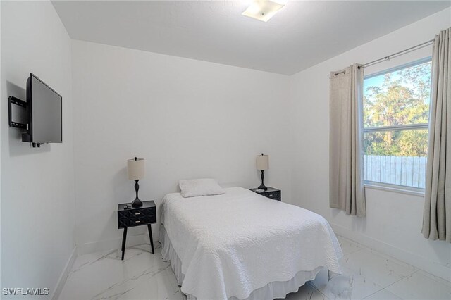 233 39th Ave NE, Naples, FL 34120 - bedroom featuring light marble finish floors and baseboards