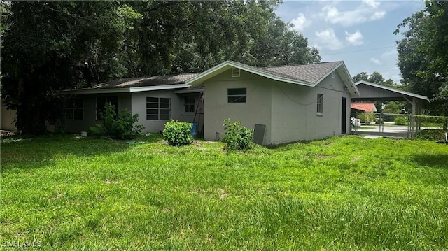 310 S Elm St, Labelle, FL 33935 - exterior space with a lawn, stucco siding, a carport, and fence
