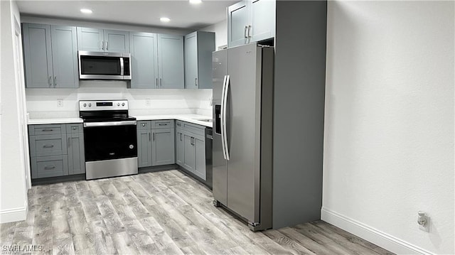 310 S Elm St, Labelle, FL 33935 - kitchen featuring light countertops, light wood-style flooring, recessed lighting, appliances with stainless steel finishes, and gray cabinets