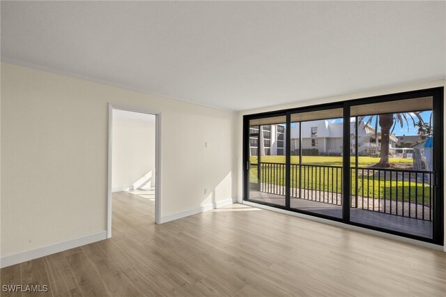 1501 Middle Gulf Dr Unit I-101, Sanibel, FL 33957 - spare room with baseboards, expansive windows, and wood finished floors