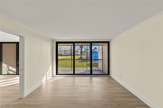 1501 Middle Gulf Dr Unit I-101, Sanibel, FL 33957 - spare room with baseboards, crown molding, and wood finished floors