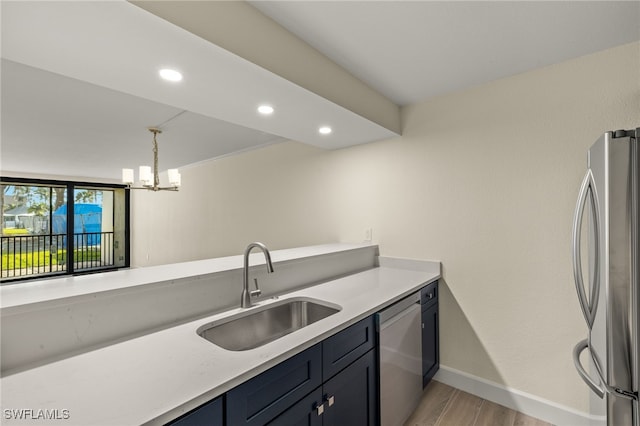 1501 Middle Gulf Dr Unit I-101, Sanibel, FL 33957 - kitchen featuring light countertops, stainless steel appliances, a chandelier, a sink, and light wood-style flooring