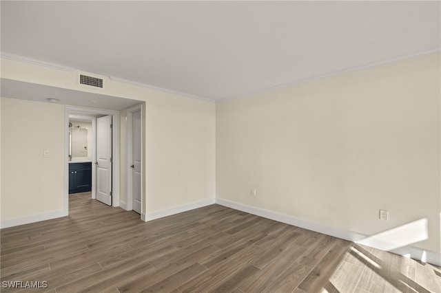 1501 Middle Gulf Dr Unit I-101, Sanibel, FL 33957 - spare room featuring baseboards, visible vents, wood finished floors, and ornamental molding