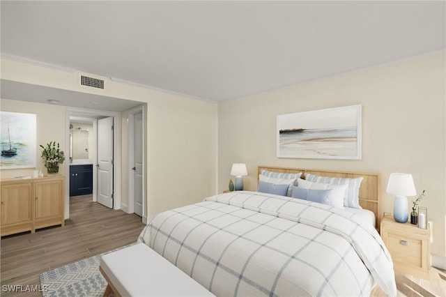 1501 Middle Gulf Dr Unit I-101, Sanibel, FL 33957 - bedroom with visible vents and light wood-style flooring