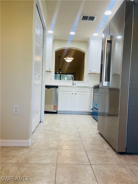7725 Woodbrook Cir Unit 3503, Naples, FL 34104 - kitchen featuring appliances with stainless steel finishes, white cabinetry, tasteful backsplash, and light tile patterned floors