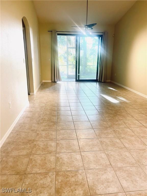 7725 Woodbrook Cir Unit 3503, Naples, FL 34104 - unfurnished room with arched walkways, light tile patterned floors, and baseboards