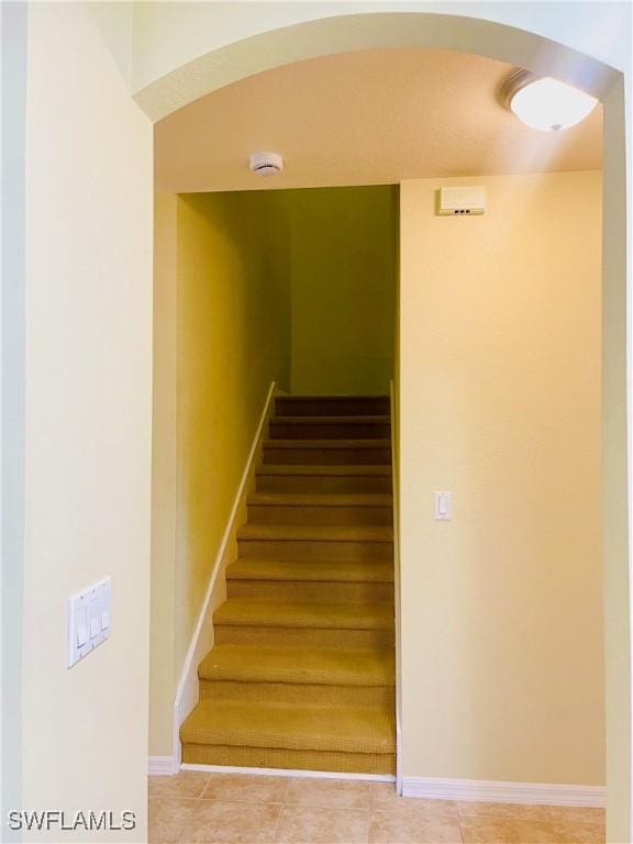7725 Woodbrook Cir Unit 3503, Naples, FL 34104 - stairs featuring arched walkways, tile patterned flooring, and baseboards