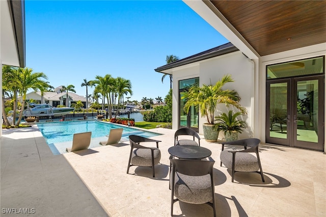 pool with french doors and a patio