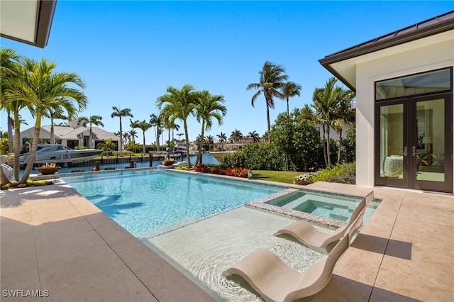 pool featuring a patio area, french doors, and an in ground hot tub