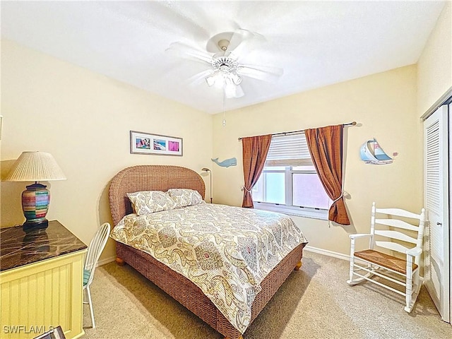 carpeted bedroom featuring a ceiling fan, a closet, and baseboards