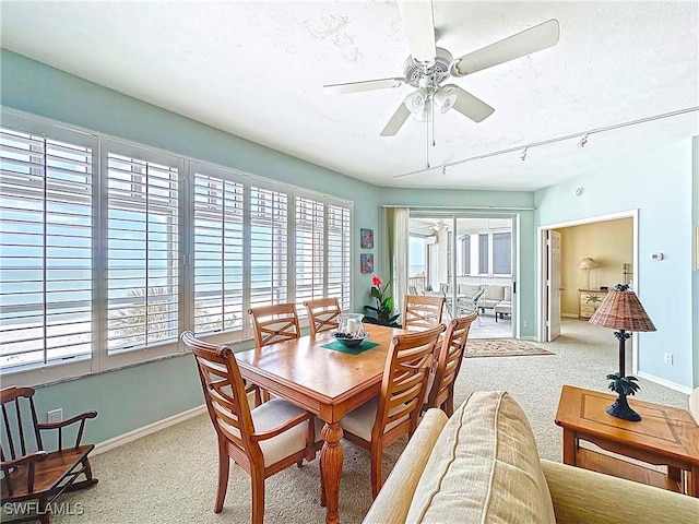 dining space with carpet floors, a textured ceiling, baseboards, and ceiling fan