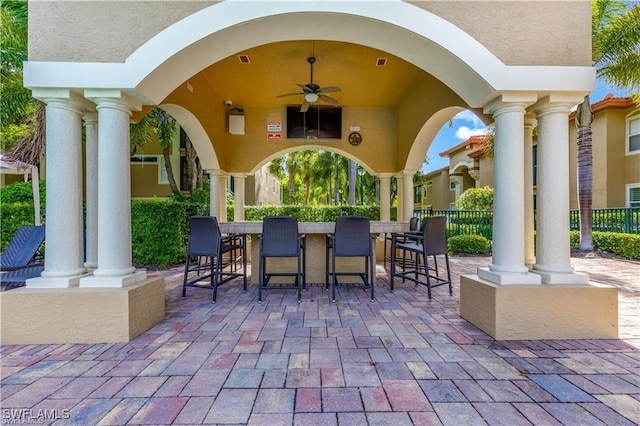 view of patio / terrace featuring ceiling fan, fence, outdoor dry bar, and a gazebo