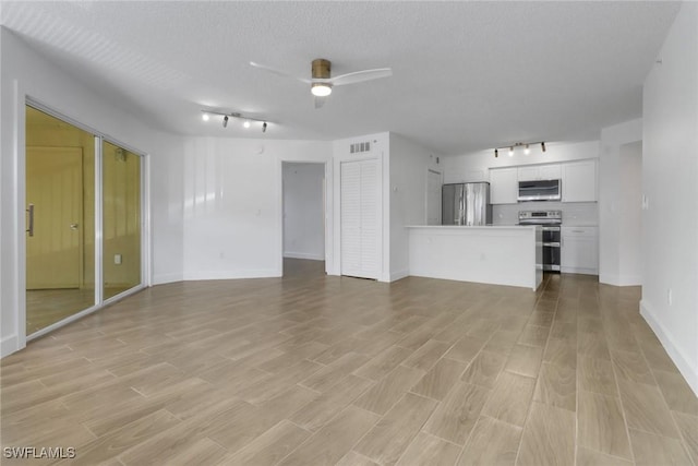 unfurnished living room featuring visible vents, baseboards, a ceiling fan, light wood finished floors, and rail lighting