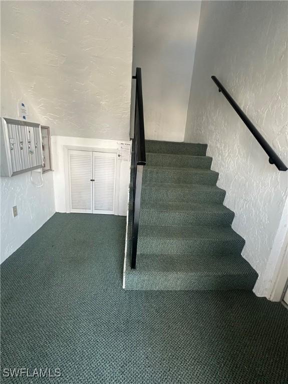 7019 Cedarhurst Dr Unit 9B, Fort Myers, FL 33919 - stairs featuring carpet floors and a textured wall