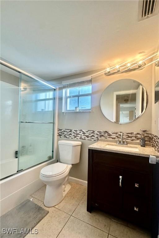 7019 Cedarhurst Dr Unit 9B, Fort Myers, FL 33919 - full bathroom featuring tile patterned flooring, visible vents, vanity, shower / bath combination with glass door, and toilet