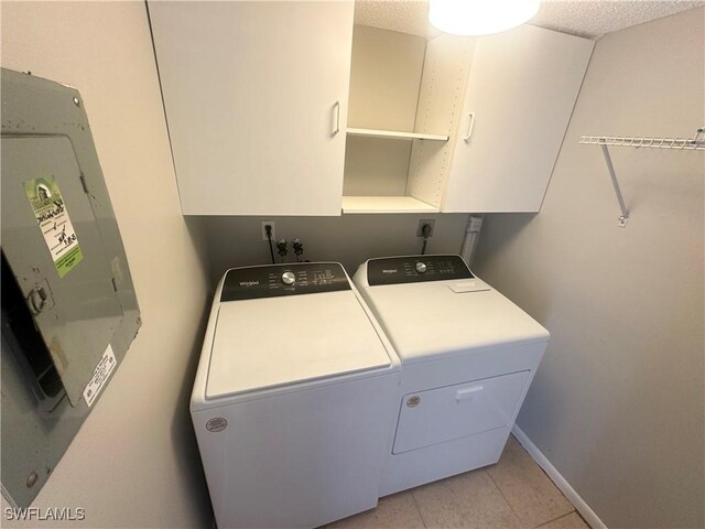 7019 Cedarhurst Dr Unit 9B, Fort Myers, FL 33919 - washroom featuring washer and dryer, baseboards, light tile patterned floors, and cabinet space