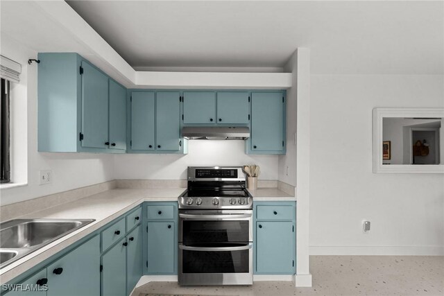 kitchen with baseboards, a sink, light countertops, under cabinet range hood, and range with two ovens