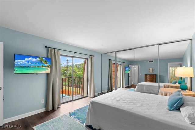 bedroom featuring visible vents, access to exterior, baseboards, and wood finished floors
