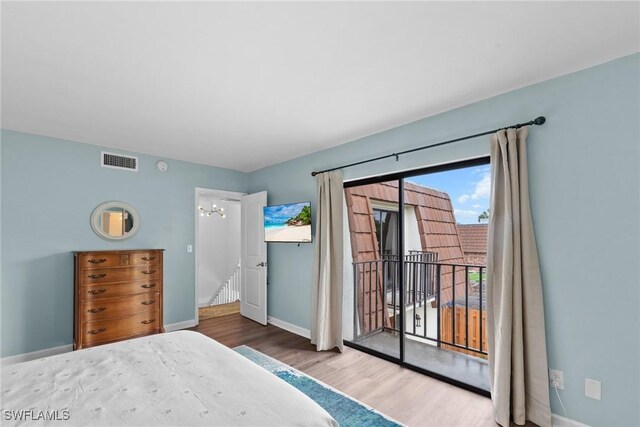 bedroom with visible vents, baseboards, access to outside, and wood finished floors