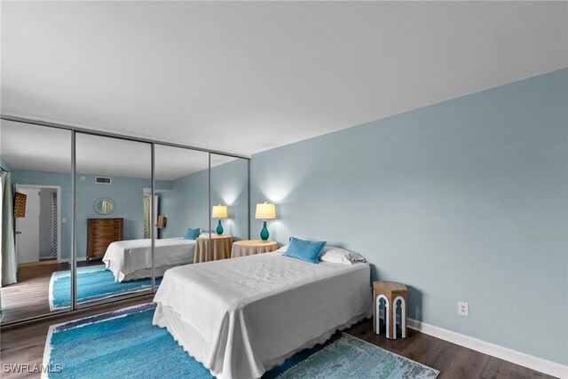 bedroom with a closet, baseboards, and wood finished floors
