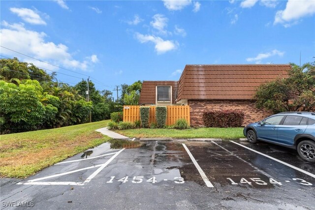 uncovered parking lot featuring fence