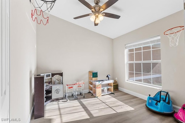 recreation room featuring baseboards, ceiling fan, and wood finished floors