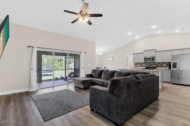 living room featuring a ceiling fan, high vaulted ceiling, baseboards, and light wood finished floors