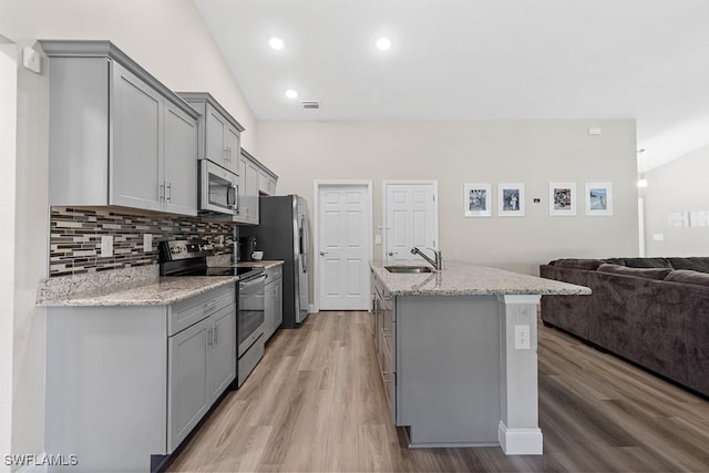kitchen with gray cabinetry, a sink, and stainless steel appliances