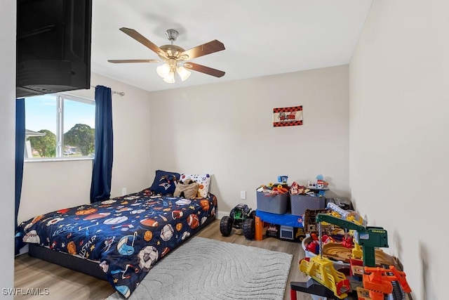 bedroom with baseboards, ceiling fan, and wood finished floors