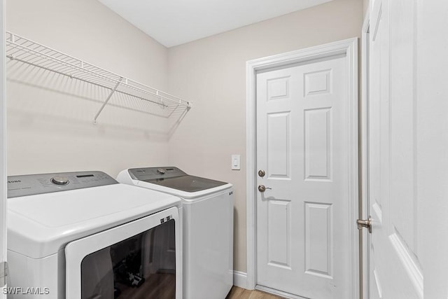 clothes washing area with washer and clothes dryer and laundry area