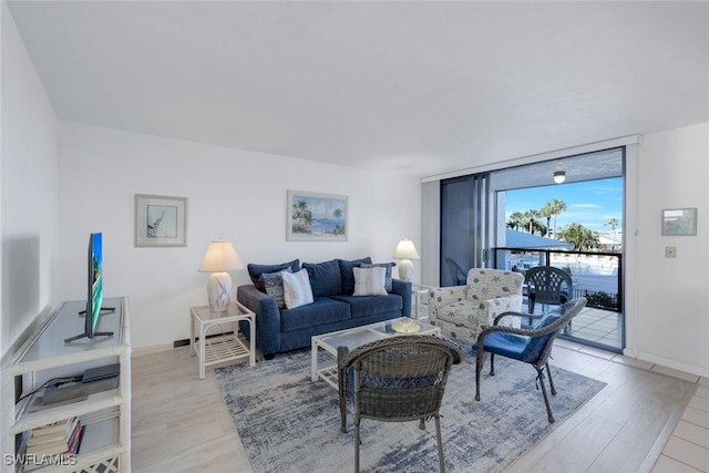 1085 Bald Eagle Dr Unit E207, Marco Island, FL 34145 - living area with baseboards, expansive windows, and light wood-style floors