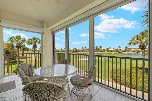 sunroom with tile patterned floors and a water view