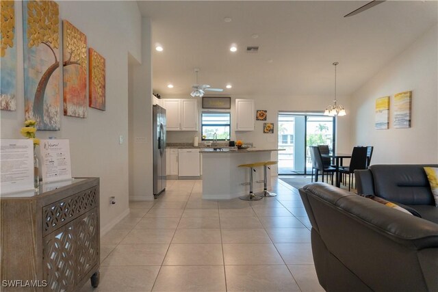 3318 SW 8th Pl, Cape Coral, FL 33914 - living area with ceiling fan with notable chandelier, light tile patterned flooring, visible vents, recessed lighting, and vaulted ceiling