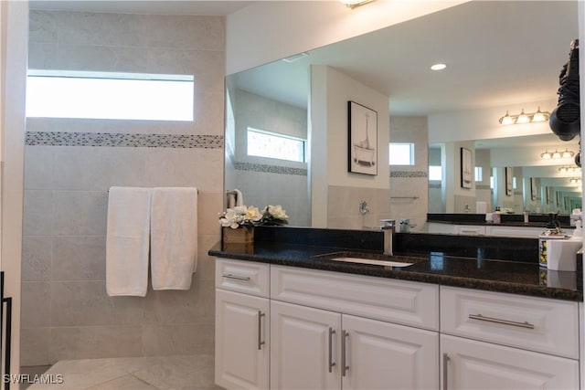 3318 SW 8th Pl, Cape Coral, FL 33914 - bathroom featuring walk in shower, tile walls, tile patterned floors, and vanity