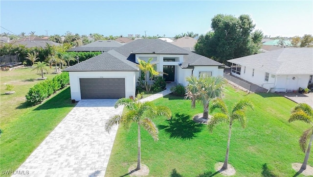 view of front of home with a front yard, decorative driveway, stucco siding, and an attached garage