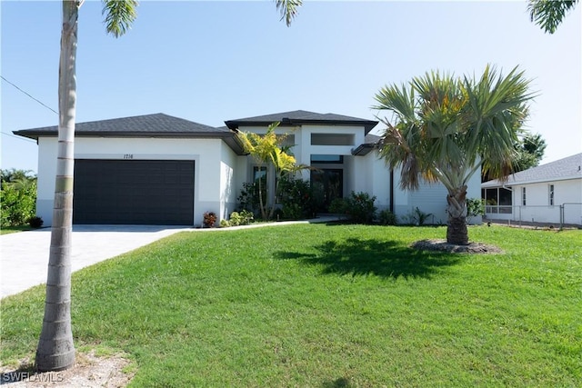 view of front of home with a front lawn, driveway, stucco siding, and an attached garage