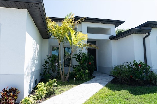 view of exterior entry with stucco siding