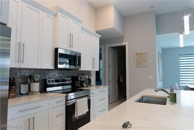 kitchen featuring decorative backsplash, a sink, light stone counters, white cabinets, and appliances with stainless steel finishes