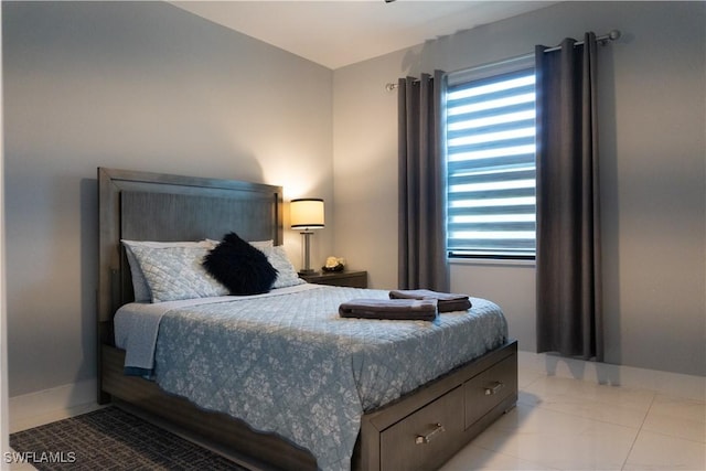 bedroom with light tile patterned floors, baseboards, and multiple windows
