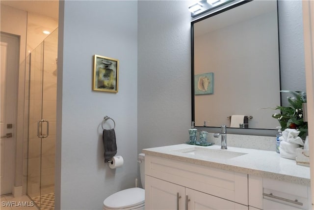 bathroom featuring toilet, vanity, and a shower stall